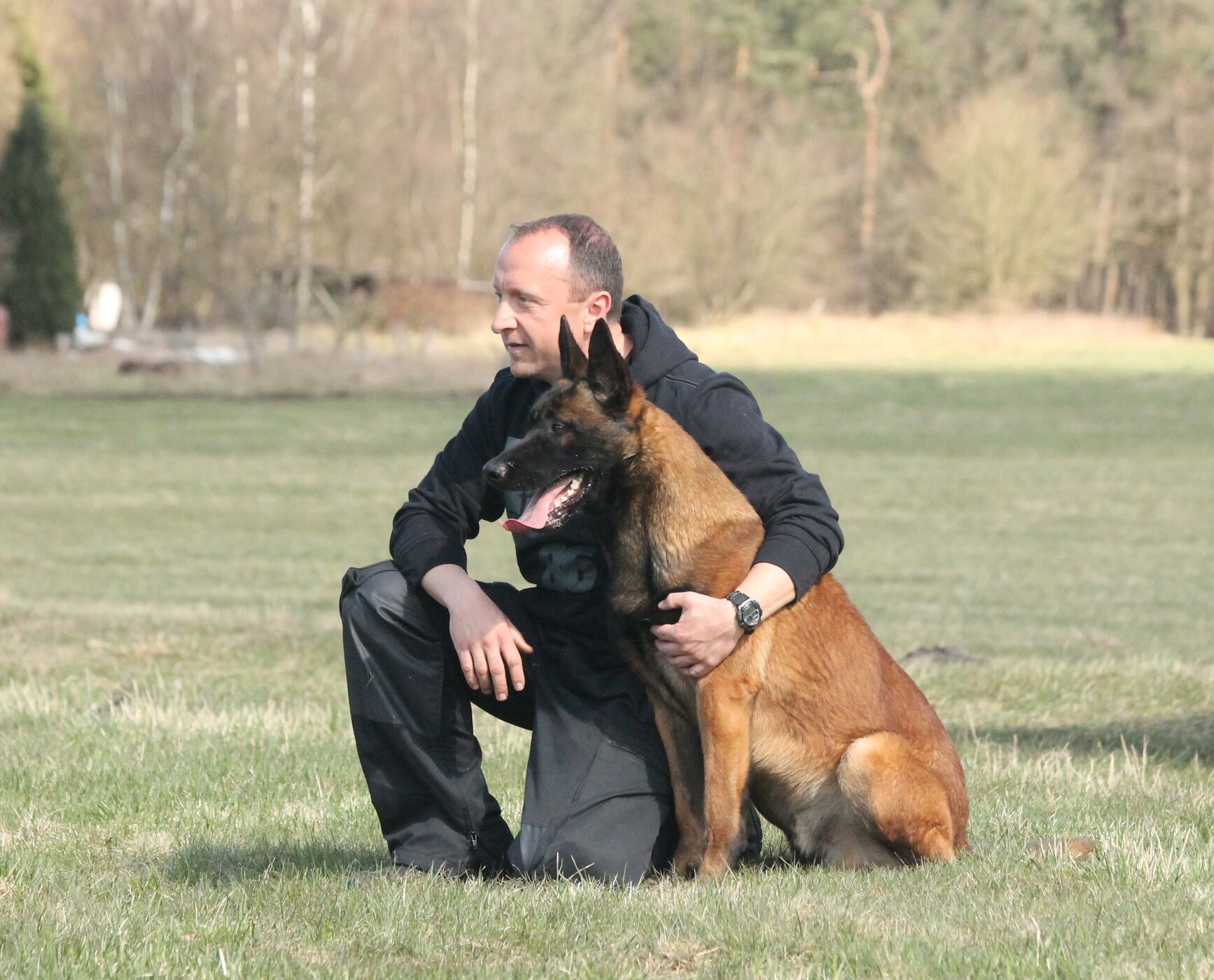 Hundetrainer Sascha Schumacher mit einem Malinois auf der Trainingswiese